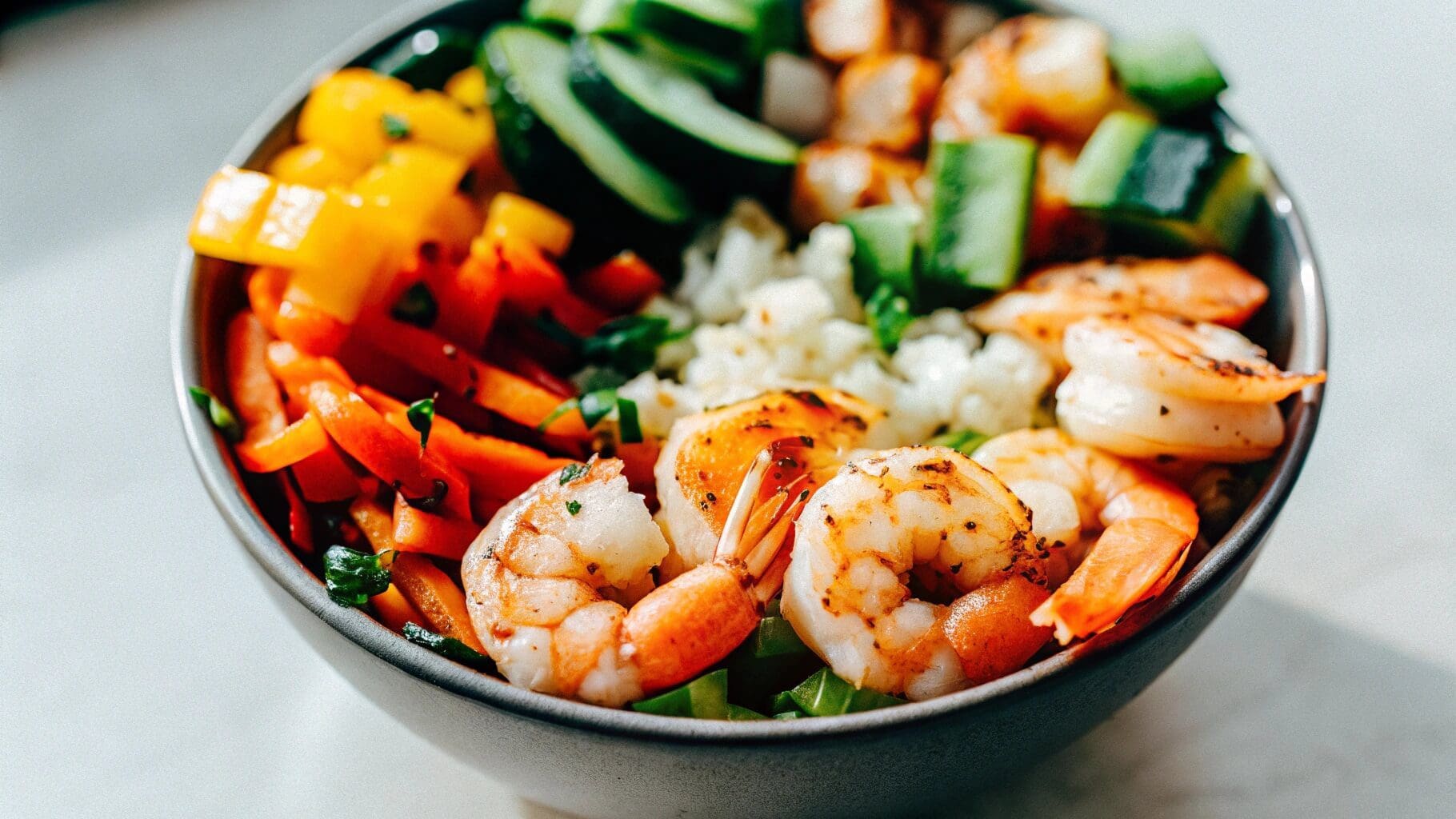 Colorful shrimp bowl with vibrant vegetables and sauce